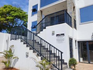 ein weißes Gebäude mit einer Treppe davor in der Unterkunft The Turk Boutique Hotel in Durban