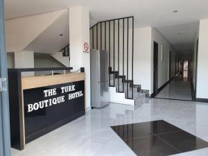 een lobby met trappen en een bord dat het kleine boetiekhotel leest bij The Turk Boutique Hotel in Durban