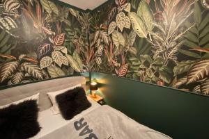 1 dormitorio con 1 cama y papel pintado con motivos florales en Altbaucharme Deluxe mit Terrasse in zentraler Lage, en Kiel