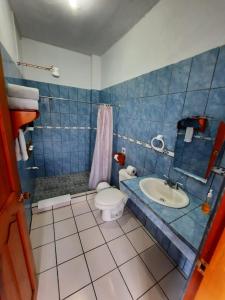 La salle de bains bleue est pourvue de toilettes et d'un lavabo. dans l'établissement Arenal Xilopalo, à Fortuna