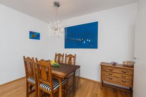 uma sala de jantar com uma mesa e cadeiras e um lustre em Apartment Breze em Split