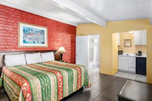 a bedroom with a bed and a red brick wall at Fallbrook Country Inn in Fallbrook