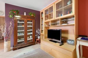 a living room with a tv and a cabinet at Appartamento IL NIDO tra verde e natura in Berbenno di Valtellina