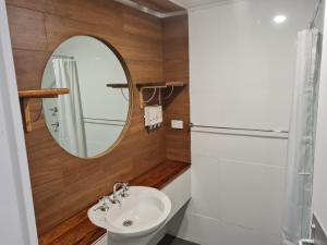 a bathroom with a sink and a mirror at John Hunter Motel Muswellbrook in Muswellbrook
