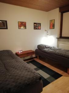 1 dormitorio con 2 camas y mesa. en Kløvermarken 14, en Herning
