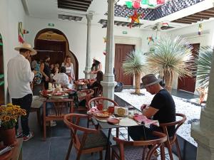 a group of people sitting at tables in a restaurant at Casa Naila Hotel Boutique in Oaxaca City