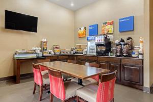Comfort Inn & Suites Greeley في غريلي: مطعم بطاولة وكراسي وكاونتر