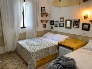 um quarto com 2 camas individuais e uma janela em Pousada Chapéu de Sol no Guarujá