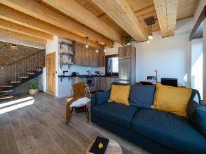 a living room with a blue couch and a kitchen at Casa Rural "Las Eras" in Fanlo del Valle de Vío