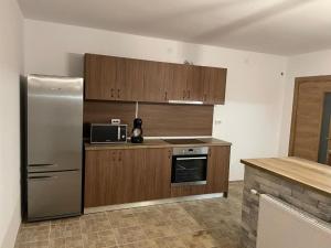 a kitchen with wooden cabinets and a stainless steel refrigerator at Villa Euphoria in Bersin