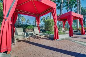 a red pavilion with chairs and tables and palm trees at SOLANA 7 Bed Rooms FAMILY VACATION VILLA-Private Pool and SPA in Davenport