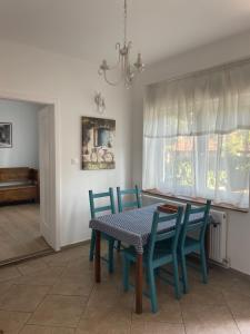 a dining room with a table and blue chairs at Pelini - 2 in Szentendre