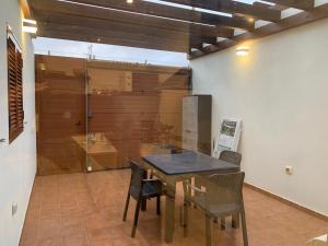 Un comedor con mesa y sillas y una ducha. en Casa Los Majos, en Corralejo