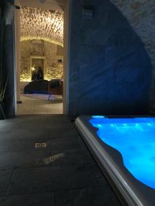 bañera de hidromasaje en una habitación con pared de piedra en jaccuzi & spa des caves Stanislas, en Nancy