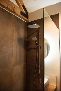 a shower with a glass door in a bathroom at The Salty Bushman B&B in Kaka Point