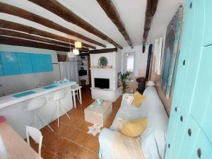 a living room with a white couch and a kitchen at Escapada al sur in Frigiliana