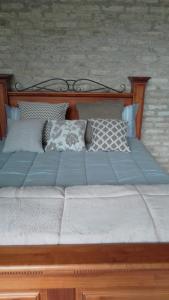 a large wooden bed with pillows on it at chale opucv in Gonçalves