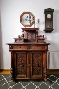 an old wooden cabinet with a clock on top of it at Dobre wCzasy in Stronie Śląskie