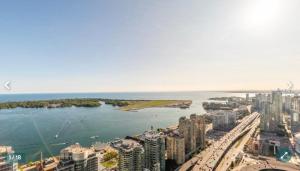 eine Luftansicht auf eine Stadt und einen Wasserkörper in der Unterkunft Million dollar lake view - 2 bedroom Cando across the lake with stunning lake view in Toronto