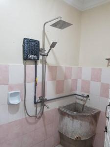 La salle de bains est pourvue d'une baignoire et d'une douche. dans l'établissement HomestayMuslim Safiyya, à Sungai Petani