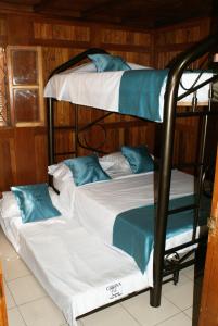 2 beliches com lençóis brancos e almofadas azuis em Chalet Condominio Campestre Rodadero Santa Marta wifi Piscina Amplia em Santa Marta