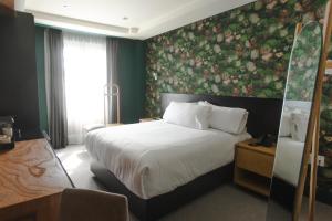 - une chambre avec un grand lit et un mur fleuri dans l'établissement Matiana Morelos, à Zacatecas