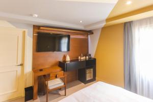 a bedroom with a bed and a tv on a wall at Matiana Morelos in Zacatecas