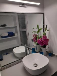 a bathroom with a white sink and a mirror at Blu Diamante in Le Diamant