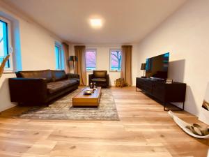 ein Wohnzimmer mit Sofa und Fernseher in der Unterkunft Home Again Studios in Rutesheim