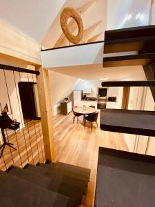 ein Wohnzimmer mit einem Tisch und einer Wendeltreppe in der Unterkunft Home Again Studios in Rutesheim