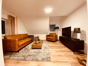 ein Wohnzimmer mit Sofa und Fernseher in der Unterkunft Home Again Studios in Rutesheim + 33 Fotos