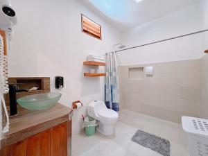 uma casa de banho com um lavatório, um WC e um chuveiro em Coconut Palm House - El Cuyo em El Cuyo