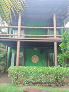 une porte d'entrée verte d'une maison avec une porte verte dans l'établissement BANGALÔ - Varandas do Mar - Praia de Itacimirim, à Camaçari