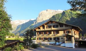 un edificio con una montagna sullo sfondo di Hotel Garni Hostatt a Engelberg