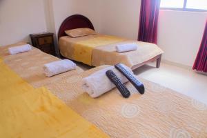 a room with two beds and two remote controls on the floor at Hotel La Makuira RB in Ríohacha