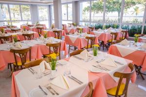 um salão de banquetes com mesas e cadeiras com toalhas de mesa laranja em Doral Guarujá no Guarujá