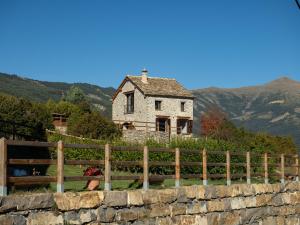 an old house on a hill behind a fence at Casa Rural "Las Eras" in Fanlo del Valle de Vío