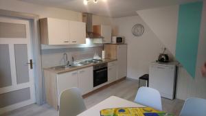 a small kitchen with white cabinets and a table and chairs at Ferienhaus Scheerer in Vöhl