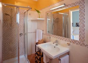 ein Bad mit einem Waschbecken und einer Dusche in der Unterkunft Marin Hotel in Pula
