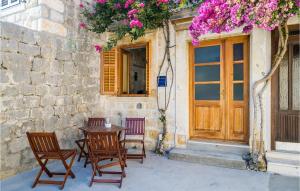 a table and chairs in front of a building with flowers at Nice Home In Donje Obuljeno in Obuljeno +29 photos