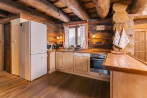 a kitchen with a white refrigerator and wooden walls at Chalet Vancouver in Donovaly