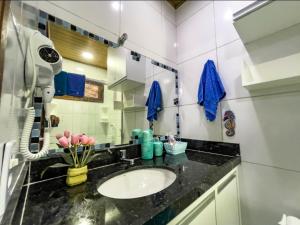 La salle de bains est pourvue d'un lavabo et d'une serviette bleue. dans l'établissement Chaleville 1601 - Inigualável, à Luis Correia