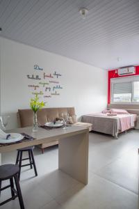 a white room with a table and a bed at Galileia flat in Santa Maria