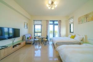 Habitación de hotel con 2 camas y TV de pantalla plana. en Dreams Come True B&B, en Xingjian