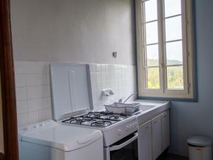 cocina blanca con fogones y fregadero en Gîte Castelnaud-la-Chapelle, 3 pièces, 4 personnes - FR-1-616-240, en Castelnaud La Chapelle