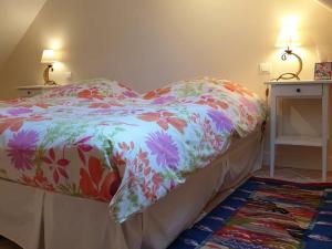 uma cama com um edredão florido num quarto em Gîte Theuville, 3 pièces, 4 personnes - FR-1-649-4 