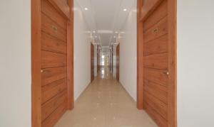 德拉敦Treebo G K Residency Near Dehradun Railway Station的大楼内带木门的走廊