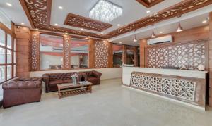 Elle comprend un salon doté d'un mobilier en cuir et d'une cheminée. dans l'établissement Treebo Trend G K Residency Near Dehradun Railway Station, à Dehradun