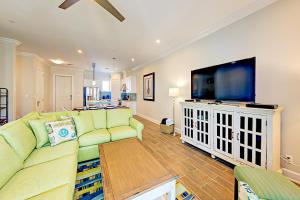 ein Wohnzimmer mit einem grünen Sofa und einem Flachbild-TV in der Unterkunft Palmilla Beach Resort II in Port Aransas