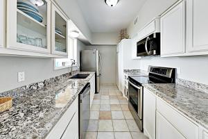 a kitchen with white cabinets and granite counter tops at La Solana Condominiums #111 in South Padre Island +27 photos